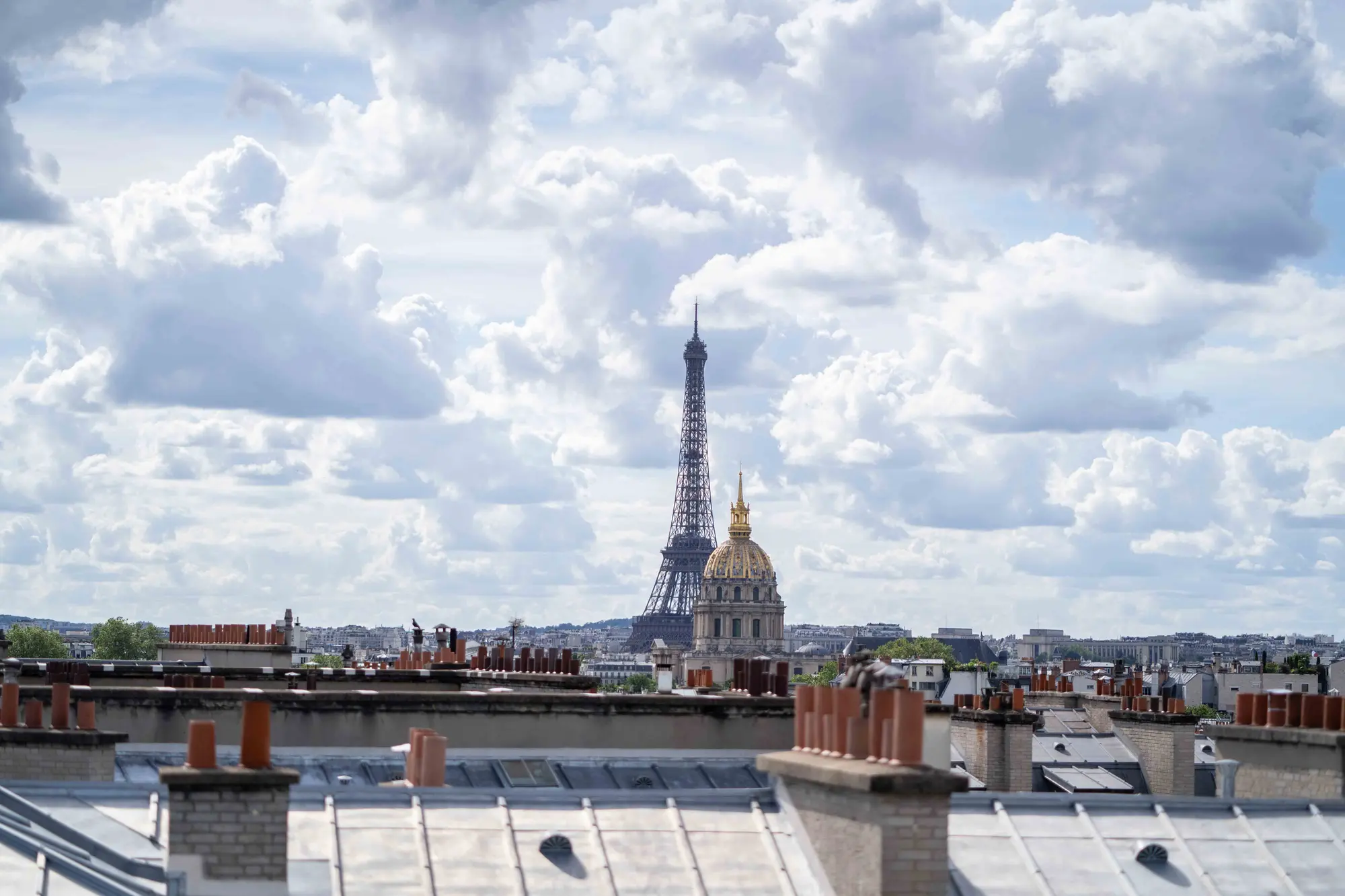 Toits en zinc et souches de cheminée de Paris, avec la tour Eiffel et le dôme des Invalides